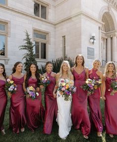 a group of women standing next to each other in front of a large white building