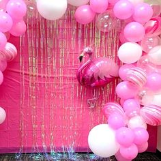 a pink flamingo themed party with balloons, streamers and streamers on the wall