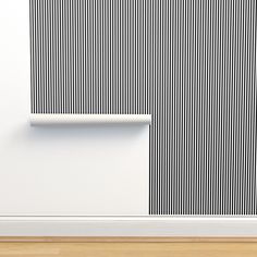 a white and black striped wall next to a wooden floor with a shelf on it