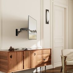 an empty room with a wooden cabinet and mirror on the wall next to a chair