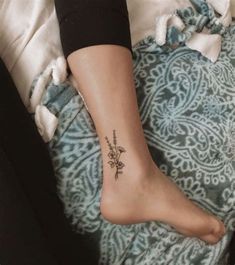 a woman's foot with a flower tattoo on the left side of her leg