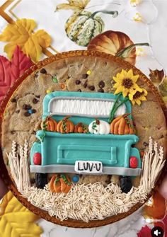 a cookie decorated to look like a truck with pumpkins and sunflowers