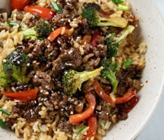 a white bowl filled with rice, meat and veggies