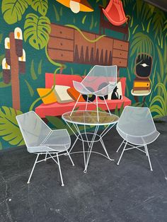 an outdoor area with chairs, tables and a mural on the wall behind it that says jungle