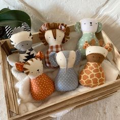 several stuffed animals are sitting in a wooden box