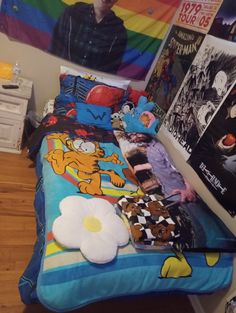 a bed room with a neatly made bed and posters on the wall next to it