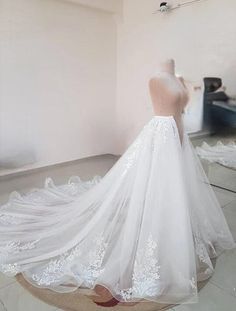 a white wedding dress on display in a room