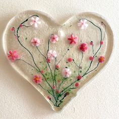 a glass heart with flowers painted on it