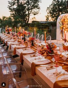 a long table is set up with place settings and candles for an outdoor wedding reception