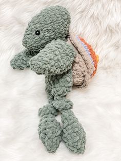 a stuffed animal laying on top of a white blanket