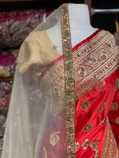 Bright Red Banarasi Silk Saree with an ensemble of fine work beads, pearls and sequins highlight intensifies the look of the Saree. Cut dana and zari work makes it a must way outfit for every bride to be. The saree has an unstitched blouse and a contrasting net dupatta is another great way to add it to your bridal wear. Fabric: Pure Silk Custom designed according to client measurements and color preference. Production and delivery time is 120 days! Transitional Gold Saree With Dori Work, Navratri Silk Thread Lehenga With Gota Work, Elegant Banarasi Silk Blouse With Dori Work, Navratri Silk Lehenga With Gota Work, Elegant Silk Thread Choli For Festive Occasions, Elegant Festive Silk Thread Choli, Elegant Festive Silk Choli, Designer Red Kundan Sets, Red Kundan Designer Wear Sets