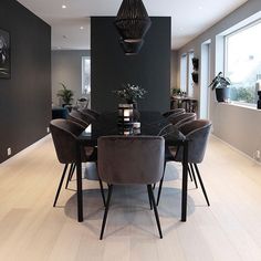 a dining room table surrounded by chairs in front of a large window