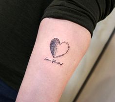 a woman's arm with a heart tattoo on it