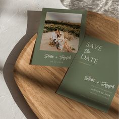 two save the dates cards sitting on top of a wooden tray