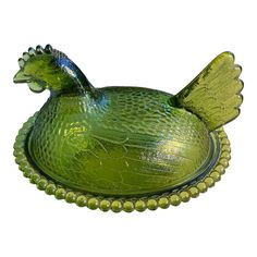 a green glass bird dish on a white background