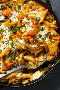 a skillet filled with pasta and vegetables