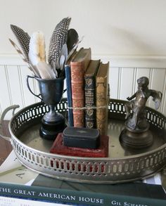 a metal tray with books and other items on it, sitting on top of a table