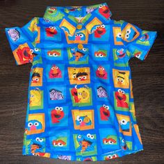 a blue shirt with sesame characters on it