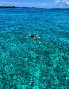 a person swimming in the clear blue water