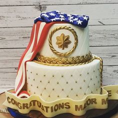 a three tiered cake decorated with an american flag and a gold shamrock on top