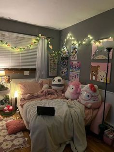 a bedroom decorated in pink and grey with teddy bears on the bed, lights strung from the ceiling