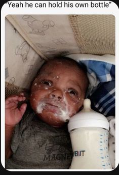 a baby is laying down with food on his face and bottle in it's mouth