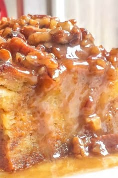 a close up of a piece of cake on a plate with syrup and pecans