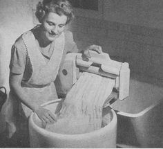 an old black and white photo of a woman washing her hands in a sink with a paper towel