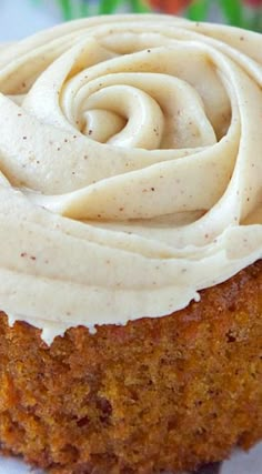 a cupcake with frosting sitting on top of a white plate