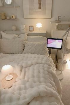 a bed with white blankets and pillows in a room