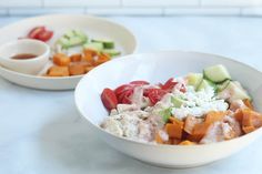 two white bowls filled with different types of food on top of a blue countertop