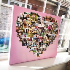 a heart shaped photo collage on a pink canvas in front of a windowsill