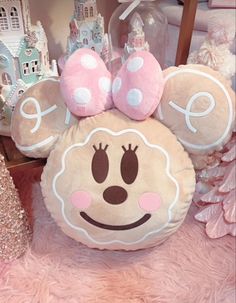 a minnie mouse pillow sitting on top of a pink rug