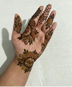 a woman's hand with hendix on it and flowers painted on the palm