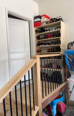 there are many pairs of shoes on the stairs in this room, and one has a blue trash can next to it