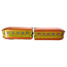 an orange and yellow train car sitting next to each other