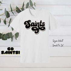 Saints Shirt  Introducing the ultimate piece of fan gear for all New Orleans Saints enthusiasts- the Saints football shirt!  Made from high-quality cotton material, this shirt is designed to be comfortable and breathable, making it the perfect choice for game day or any casual occasion. The vibrant black and gold colors are sure to catch the eye of any Saints fan. This shirt is a must-have for any true Saints fan. Whether you're cheering from the stands or watching from home, you can show your support for the team in style with this top-quality football shirt. Don't miss out on the chance to own a piece of Saints history - order your Saints football shirt today! Sizes: Unisex adult sizes small-3X. See size chart in listing photos. Ships in 3-5 business days. Need an item by a specific date Black Team Spirit Shirt For Football Season, Black Shirt With Team Name For Fans, Black Short Sleeve Shirt For Football Season, Black Fan Apparel Shirt For Game Day, Black Shirt With Team Name For School Spirit, Black Letter Print Shirt For Game Day, Black Shirt With Letter Print For Game Day, Black Shirt With Text Print For Game Day, School Spirit Black Shirt With Team Name