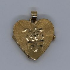 This hand-made heart locket is as sentimental and unique as it gets. It is a perfect Valentine's Day present. It is made of 14 karat gold. It is both beautiful and functional. Most lockets can hold 2 pictures but this one can hold 4 special photos close to your, or your loved one's heart! The photos are easy to slip through slots at top of locket. It is hard to match the workmanship of this locket and it's engraving. It was crafted by a very talented jeweler in the NYC jewelry district between 1 Collectible Gold Jewelry With Heart Charm, Antique Heart-shaped Yellow Gold Jewelry, Heirloom Yellow Gold Locket Necklace With Charms, Heirloom Locket Necklace For Valentine's Day, Heart-shaped 14k Yellow Gold Locket Necklace, Heart Shaped 14k Yellow Gold Locket Necklace, 14k Yellow Gold Heart Locket Necklace, Victorian 14k Gold Heart Jewelry, Victorian 14k Gold Heart-shaped Jewelry