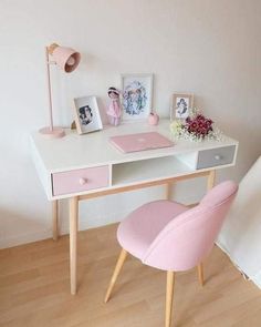 a white desk with pink chairs and pictures on it