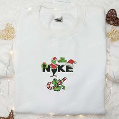 The Grinch Xmas x Nike Movie Embroidered Sweatshirt, Christmas Embroidered Shirt, Best Christmas Gift Ideas Welcome to Tinicloset, the ultimate destination for all your custom embroidered clothing needs! At Tinicloset, we specialize in creating one-of-a-kind embroidered shirts, sweatshirts, t-shirts, and hoodies that are as unique as you are. Our collection features a wide range of... White Tops With Embroidered Logo For Christmas, White Top With Embroidered Logo For Christmas, Christmas Crewneck Sweatshirt Nike, White Tops With Custom Embroidery For Christmas, Christmas White Embroidered Tops, Custom Christmas Nike Sweatshirt, White Christmas Tops With Embroidered Graphics, Grinch Nike Sweatshirt, Grinch Nike Embroidery