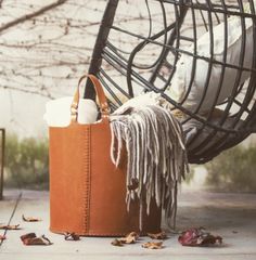 a brown leather bag sitting on top of a wooden chair