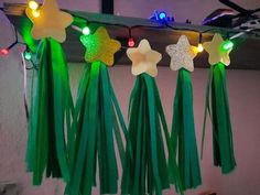 some lights are hanging from the ceiling and green tassels have stars on them