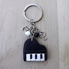 a black and white piano keychain with keys attached to it