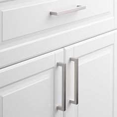 a white cabinet door with two handles on it