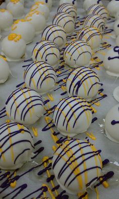 white and yellow desserts are lined up on a sheet of paper with blue and yellow sprinkles