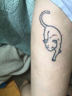 a cat tattoo on the leg of a person's leg, which is drawn in black ink