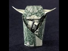 an origami bull's head made out of dollar bills on a black background