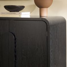 a black cabinet with a brown bowl on top