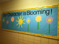 a sign that says our character is blooming in front of a tiled wall with flowers