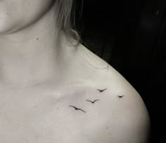 a woman's chest with two birds on the left side of her chest and one bird flying in the air